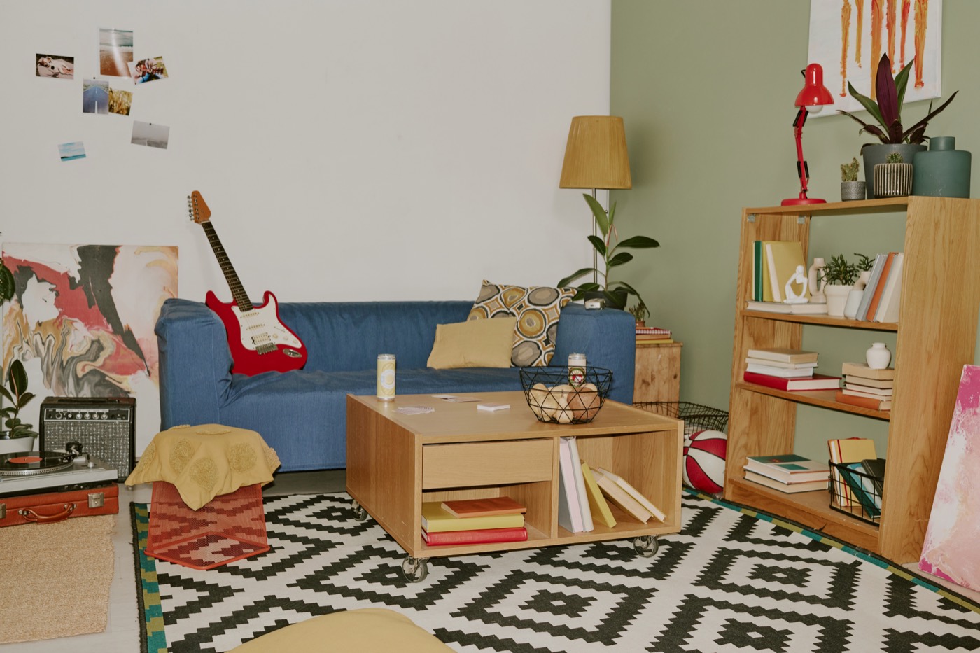 A calm living room with a low sofa and a tall warm lamp beside the bookshelf.