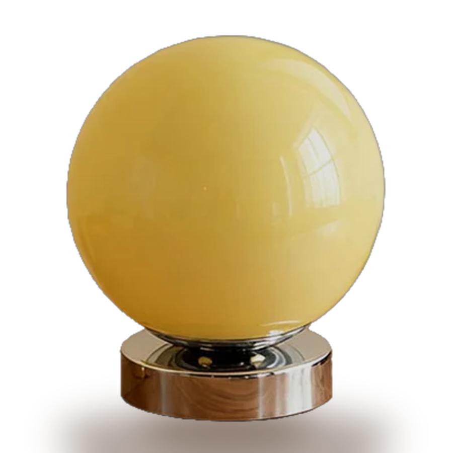 Balloon — a single sphere of pale yellow blown glass on a polished chrome puck.